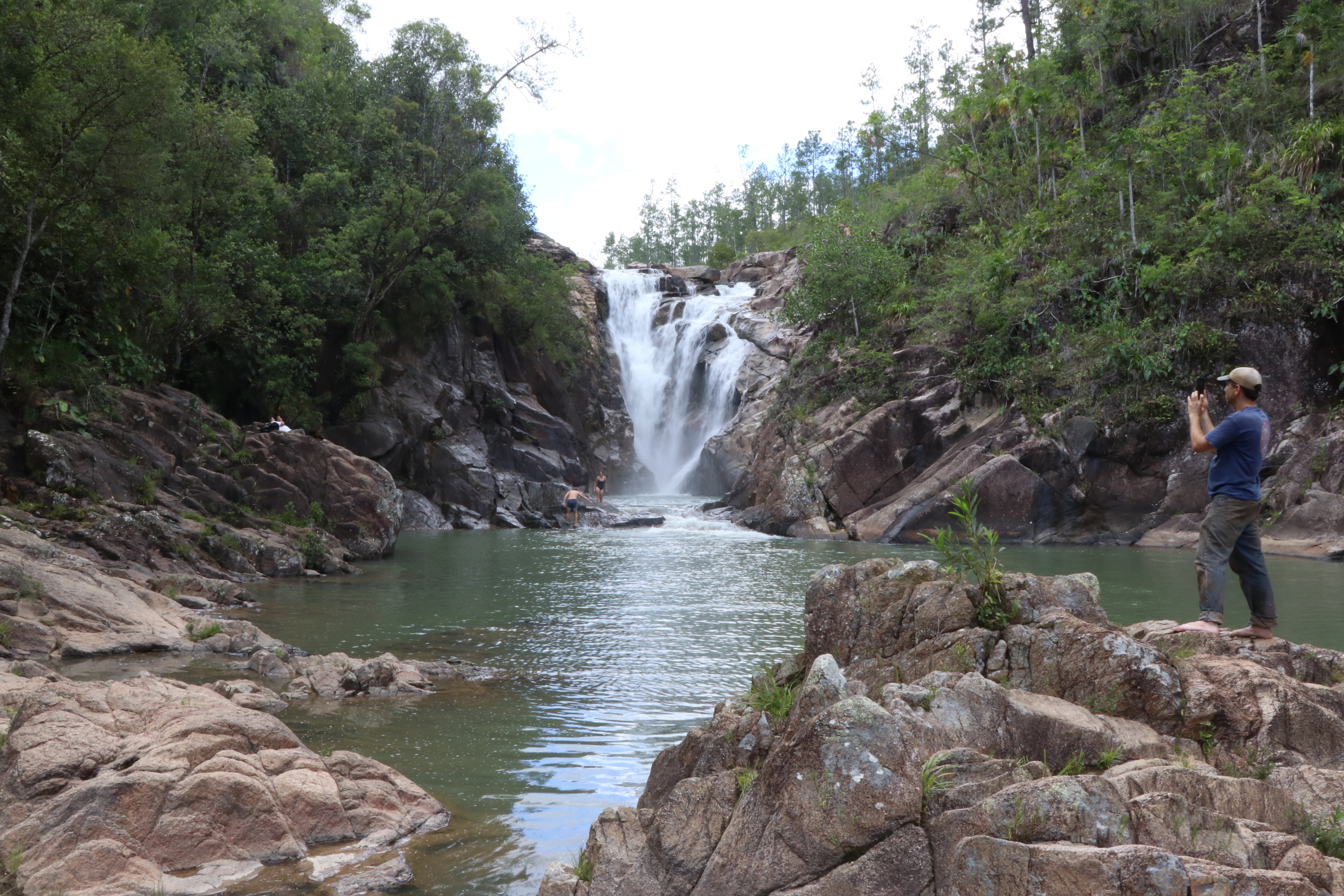 A waterfall surrounded by trees and boulders