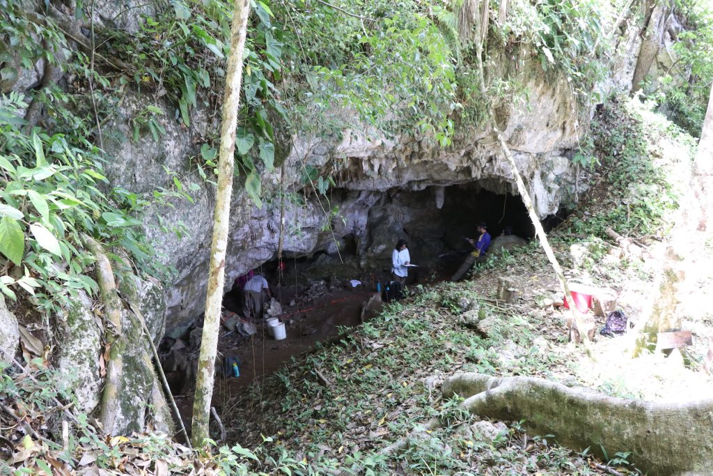People standing in cave entrance